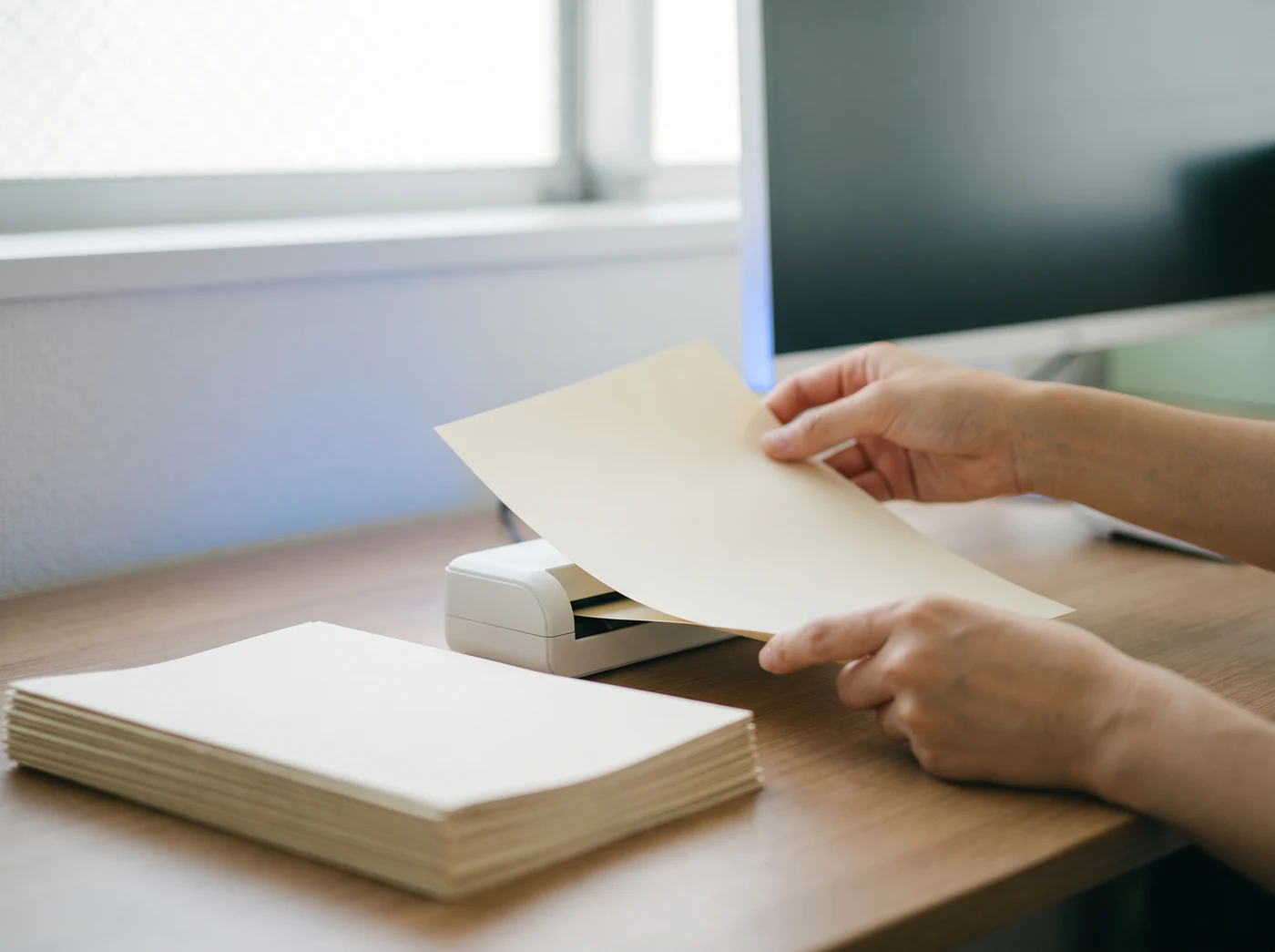 事務所で請求書をスキャナーで読み取る様子